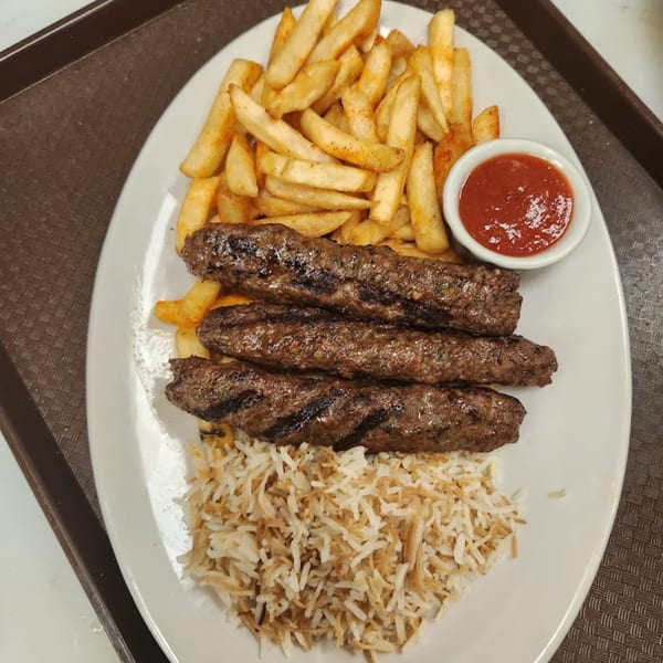 Three grilled Habibi's kofta kebabs with rice, french fries, and a side of ketchup.