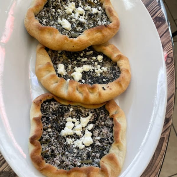 Three spinach and feta fatayer, or savory pies, on a white plate at Habibi's Cafe & Pizzeria.